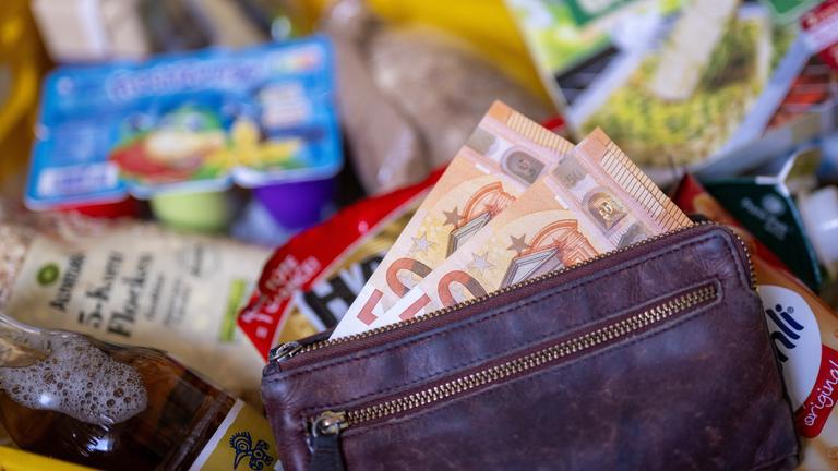 Berlin: Ein Geldbeutel gefüllt mit Geldscheinen liegt nach dem Einkauf in einem mit diversen Lebensmitteln gefüllten Einkaufskorb. 