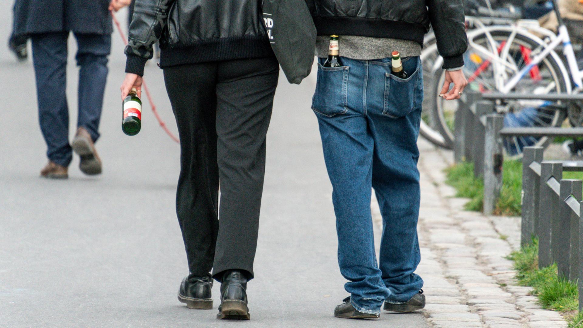 Junge Leute tragen Bierflaschen in den Hosentaschen (Archivbild)