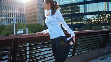Joggerin bei einer Dehnübung vor einem Lauf in der Stadt