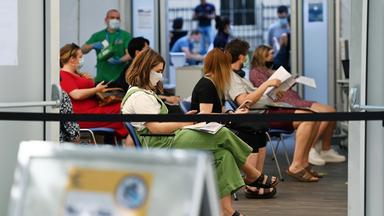 Menschen warten in Großbritannien im Impfzentrum auf ihre Impfung gegen das Coronavirus 