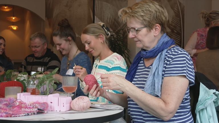 Alte und junge Menschen stricken gemeinsam in einem Strick-Club