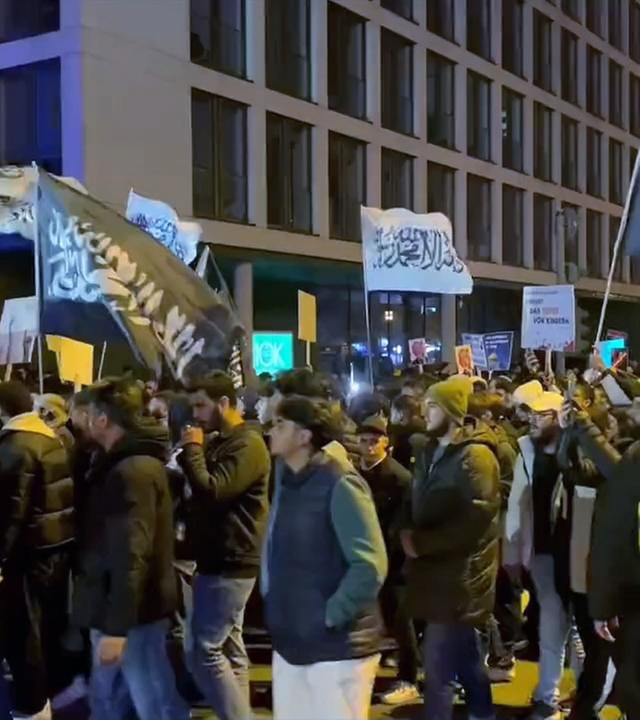 Schwarz-weiße Flaggen mit Glaubenbekenntnissen auf Demo in Essen