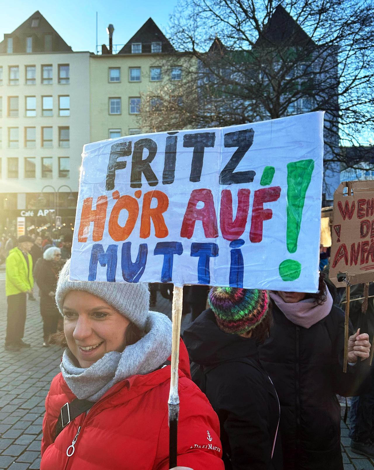Ein Schild mit der Aufschrift "Fritz, hör auf Mutti!" ist bei einer Demonstration gegen die Migrationspolitik der CDU in der Innenstadt zu sehen.
