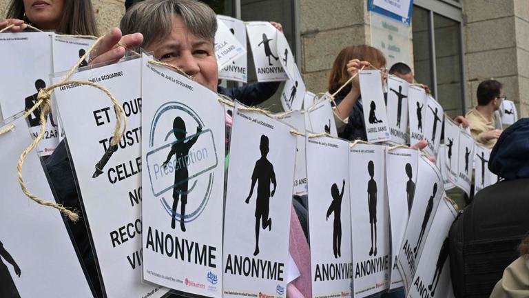 Demonstranten halten Schilder mit den Namen der Opfer während einer Demonstration vor dem Gerichtsgebäude. 