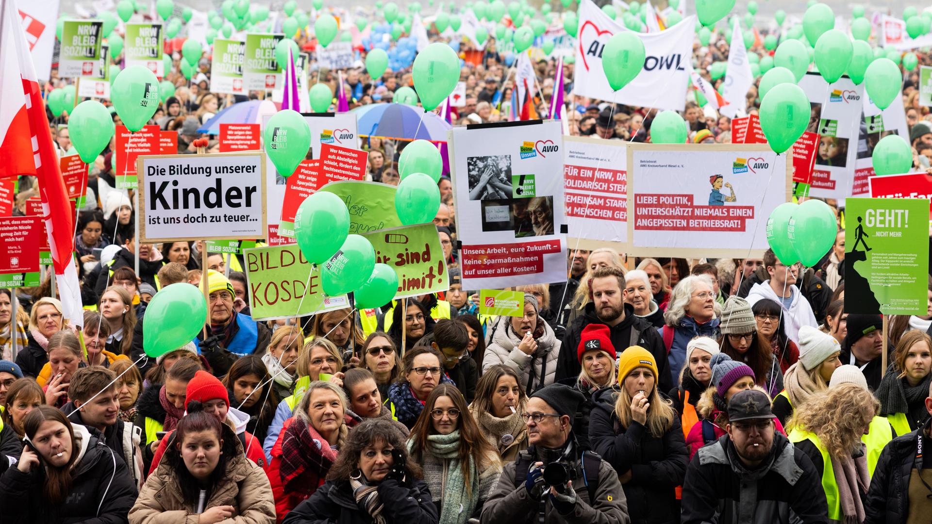  Menschen versammeln sich zu einer Kundgebung von Wohlfahrtverbänden gegen geplante Kürzungen der Landesregierung auf den Oberkasseler Rheinwiesen.