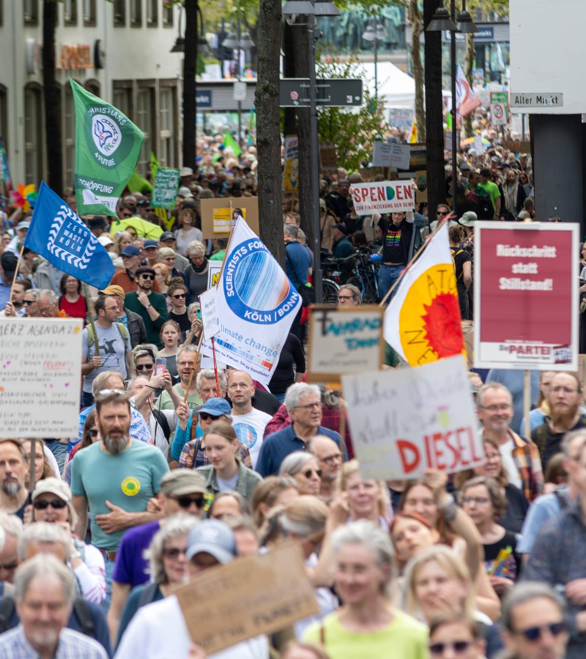 Demonstratanten ziehen durch Köln und halten Schilder hoch