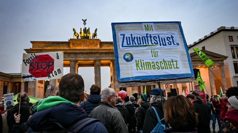 Berlin: Demonstranten der Klimabewegung Fridays for Future stehen anlässlich der Weltklimakonferenz COP30 am Brandenburger Tor.