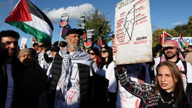Eine Frau hält bei einer pro-palästinensischen Demonstration unter dem Motto „United4Palestine“  in Berlin ein Plakate hoch. Hinter ihr stehen weitere Demonstranten. 