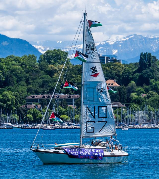 Auf einem Segel eines Schiffs auf dem Genfersee ist mehrfach die Aufschrift "No G7" zu lesen. 