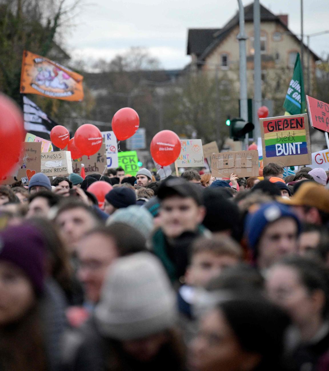 Demonstranten halten Plakate mit der Aufschrift „Giessen bleibt bunt“ hoch während einer Protestaktion.