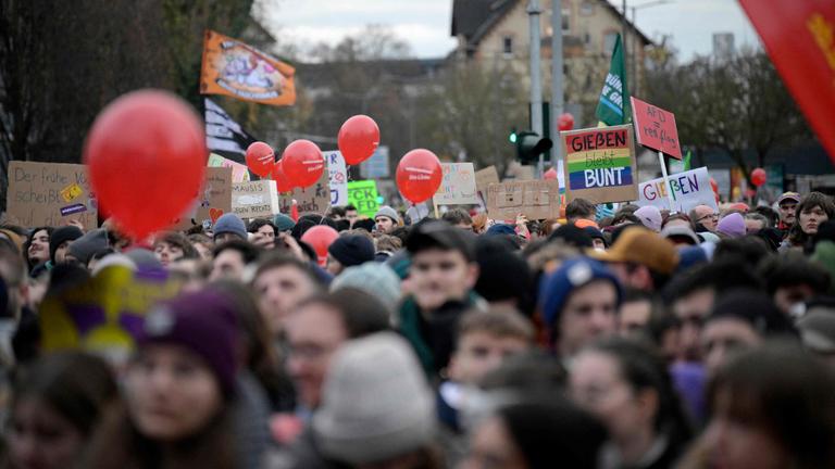 Demonstranten halten Plakate mit der Aufschrift „Giessen bleibt bunt“ hoch während einer Protestaktion.