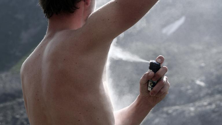 Mann benutzt Deodorant-Spray