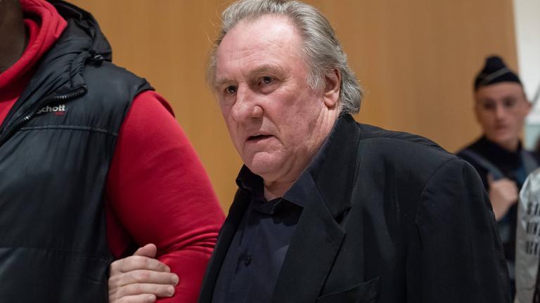 French actor Gerard Depardieu walks with his lawyer Jeremie Assous as he arrives for the opening of his trial in which he is accused of sexually abusing two women during a film shoot in 2021, at the Paris criminal court in the Tribunal de Paris courthouse, on March 27, 2025.
