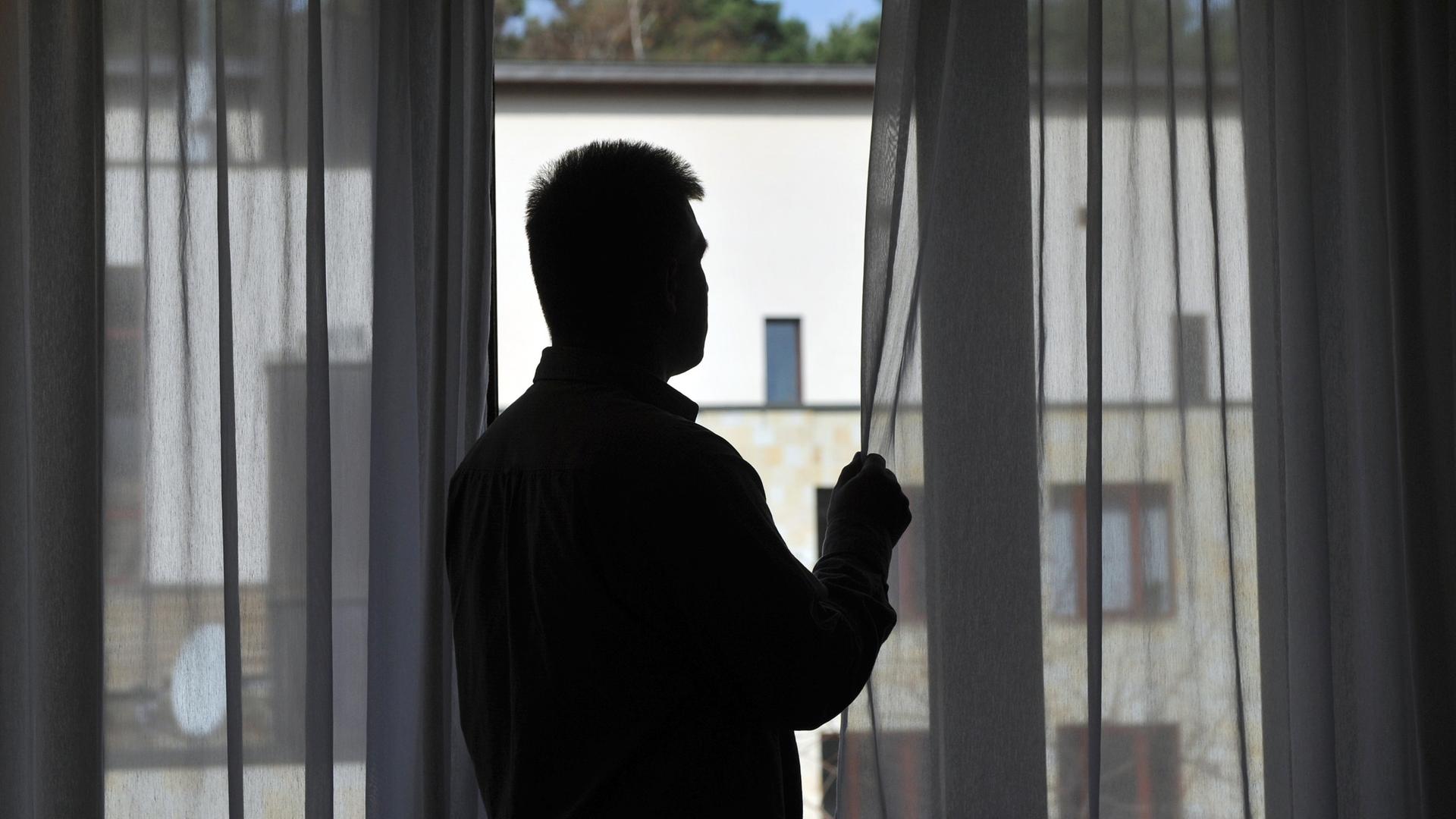 Ein Mann steht am Fenster seines Zimmers in der Oberbergklinik in Rietz, aufgenommen am 01.04.2011
