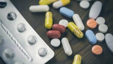 Verschiedene Tabletten und Pillen liegen auf einem Tisch