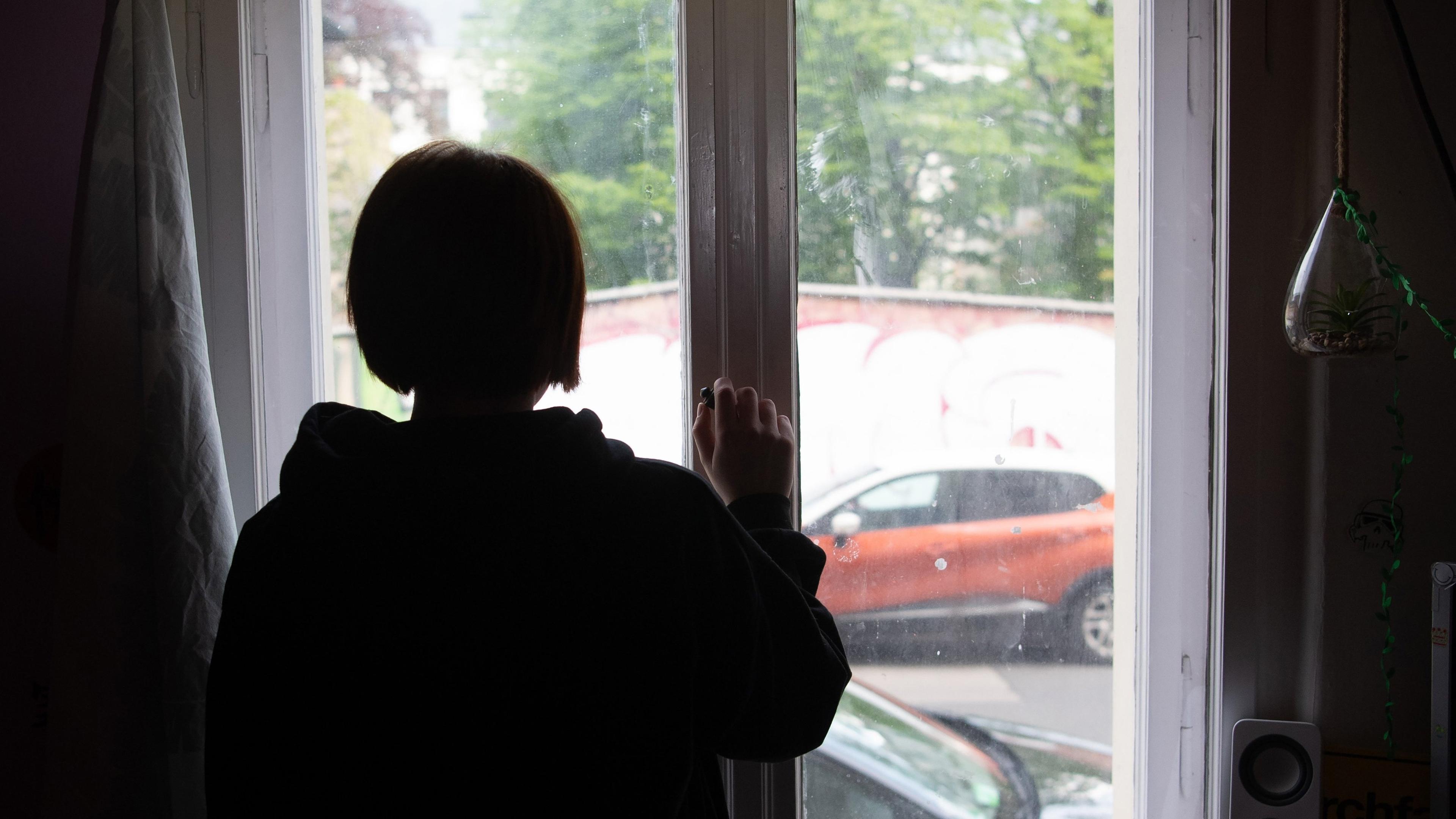 Brandenburg, Potsdam: Eine Jugendliche blickt aus einem Fenster.