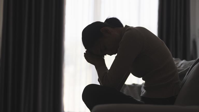 Frau alleine Auf Sofa - Symbolbild für Depressionen