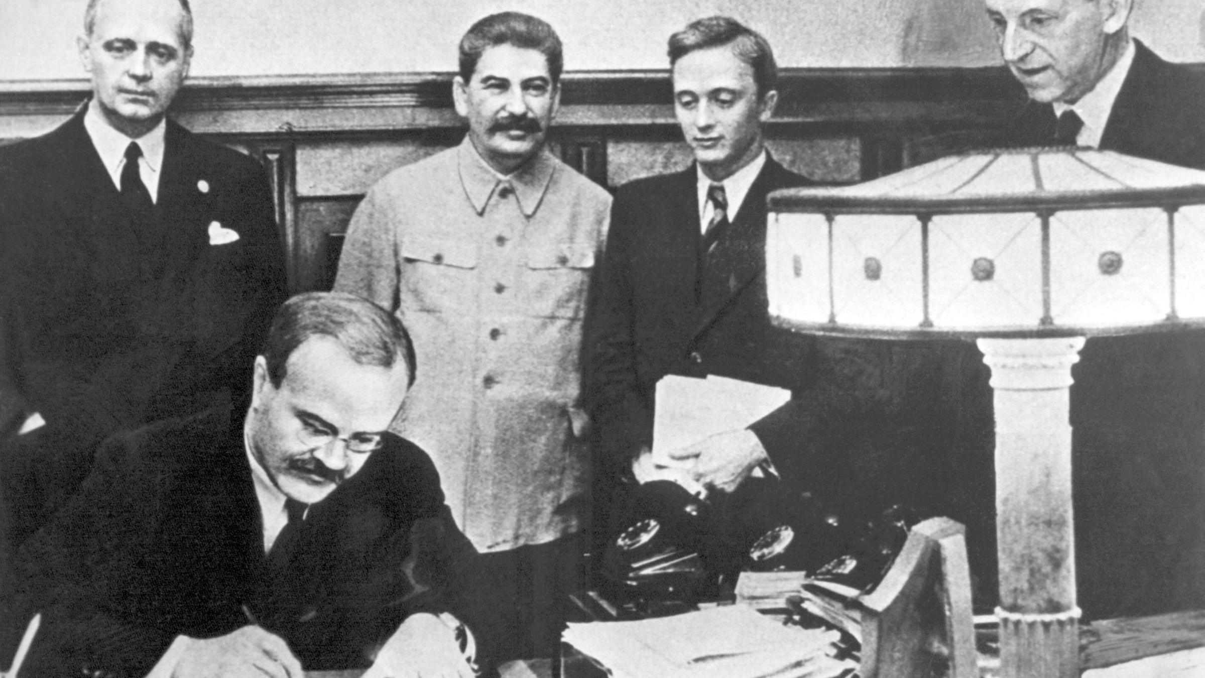 Am 23. august 1939 unterzeichneten der Außenminister des Deutschen Reiches, Joachim von Ribbentrop (l), und der sowjetische Außenminister Wjatscheslaw Molotow (vorn) in Moskau den deutsch-russischen Nichtangriffspakt. Hinten neben Ribbentrop Josef Stalin, ganz rechts Friedrich Gaus, daneben U. Pavlov.