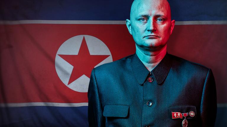 "Der Maulwurf - Undercover in Nordkorea: Freunde von Kim Jong Un ": Ein Mann in einer Uniform mit militärischen Abzeichen blickt ernst in die Kamera – im Hintergrund die nordkoreanische Flagge.