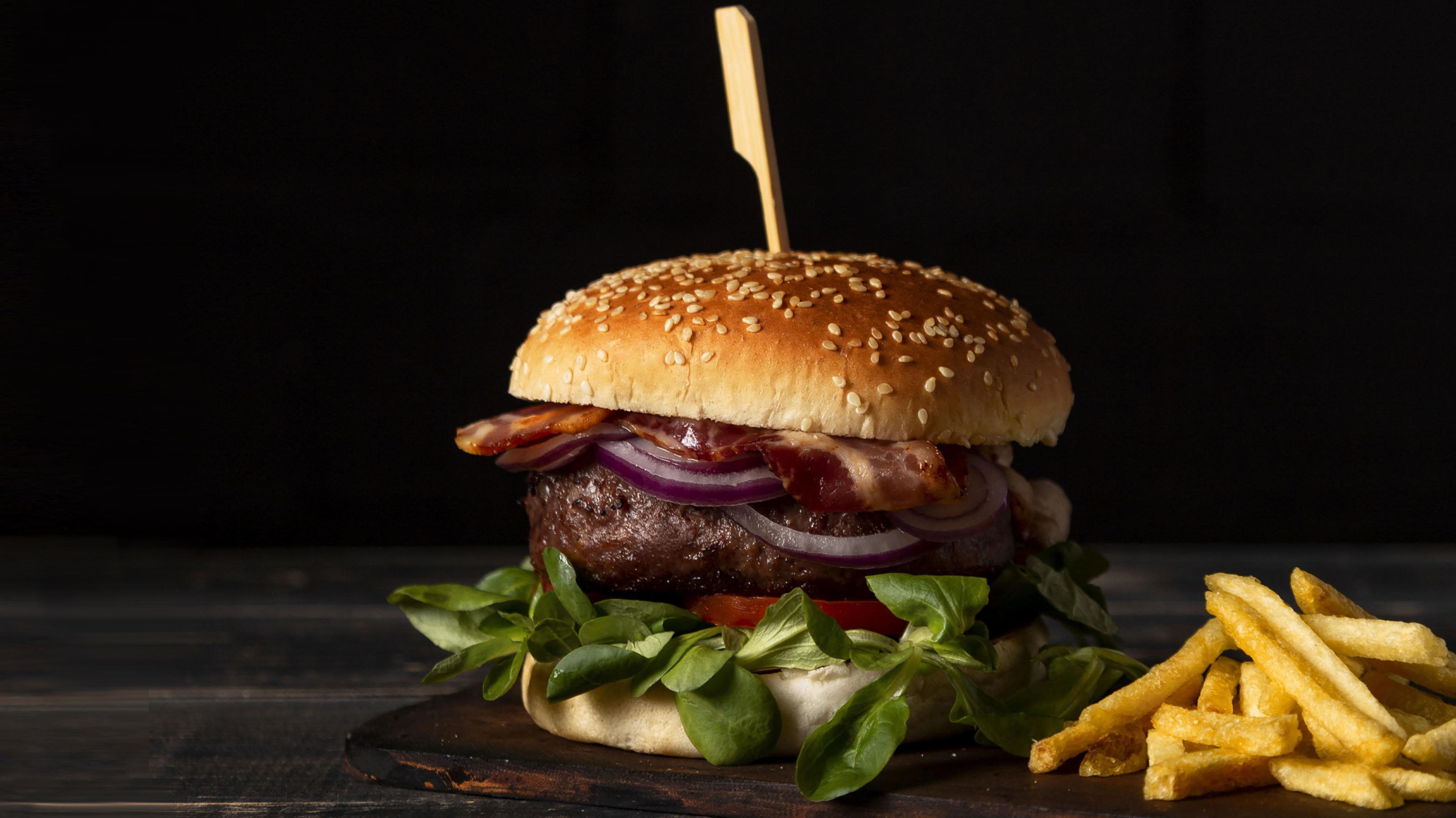 Ein Hamburger und eine Portion Pommes frites auf einem Tisch.
