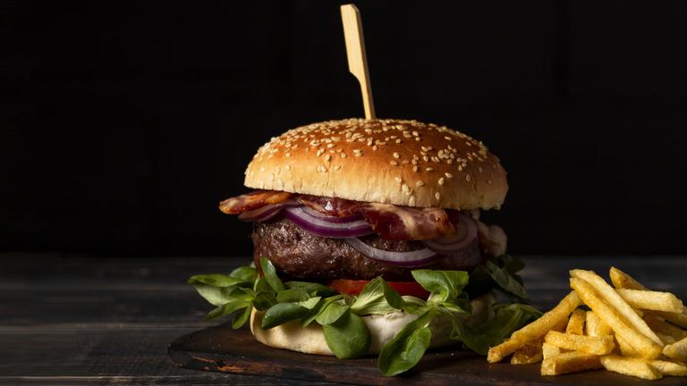 Ein Hamburger und eine Portion Pommes frites auf einem Tisch.