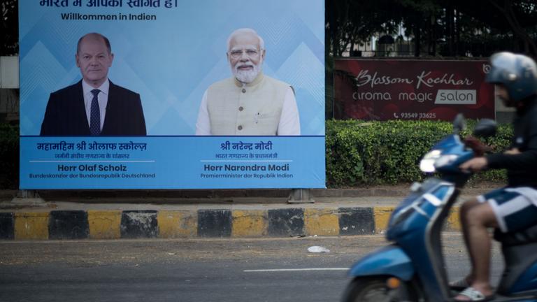  Ein Schild mit dem Bild von Bundeskanzler Scholz und dem indischen Premierminister Modi sowie dem Satz ·Willkommen in Indien· steht vor den deutsch-indischen Regierungskonsultationen vor dem Eingang an einer Straße in Neu Delhi, Indien am 24.10.2024