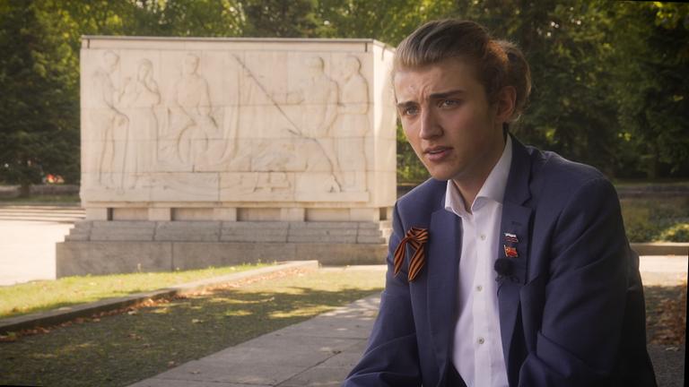Junger Abiturient sitzt am Ehrenmal der Sowjetarmee im Treptower Park in Berlin