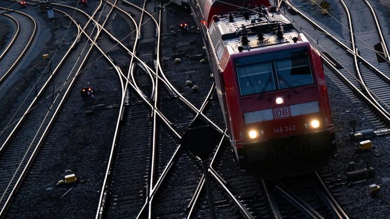 Symbolbild:  Ein Zug der Deutschen Bahn (DB) fährt auf einem Gleis aus dem Hauptbahnhof. 