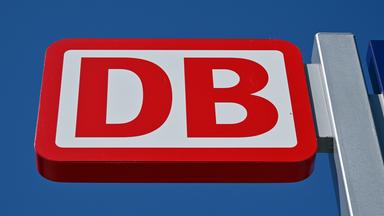  Das Logo der Deutschen Bahn vor blauem Himmel.