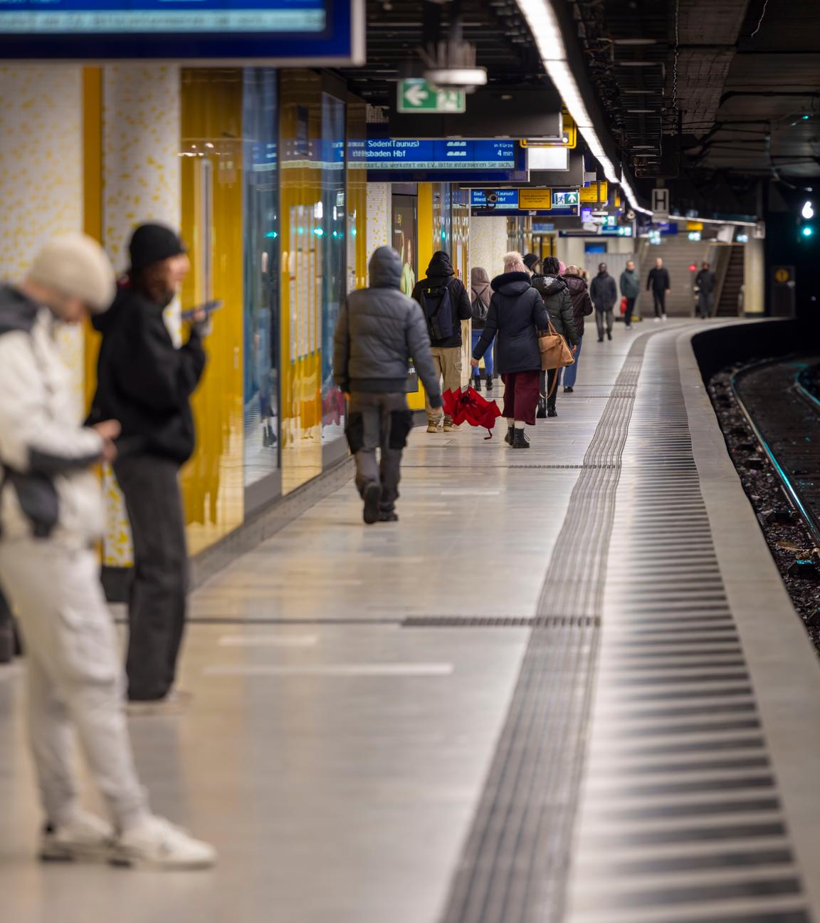 Menschen warten auf einem Bahnsteig