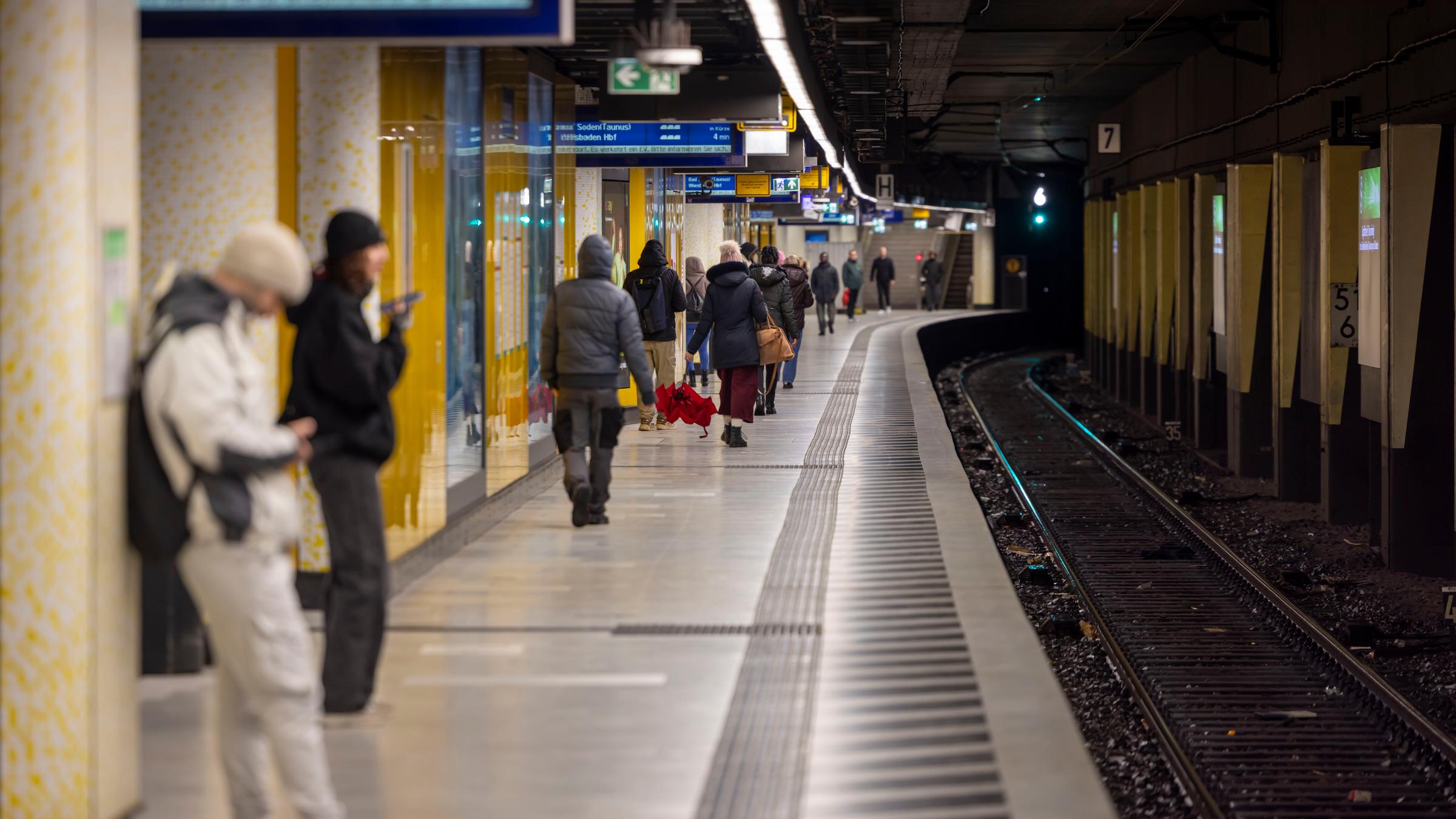 Menschen warten auf einem Bahnsteig