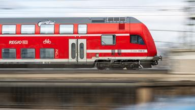 Ein Regionalexpress der DB Regio fährt über eine Brücke.