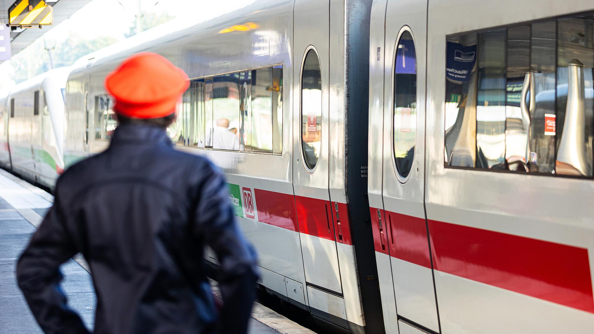Niedersachsen, Hannover: Ein Mitarbeiter der Deutschen Bahn (DB) steht neben einem ICE-Zug an einem Gleis im Hauptbahnhof Hannover. Archivbild