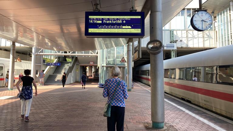 07.09.2024, Kassel: Ein Frau steht auf dem Bahnsteig und schaut sich eine Anzeige der Deutsche Bahn an. Foto: Verena Schmitt-Roschmann/dpa +++ dpa-Bildfunk +++; No data!