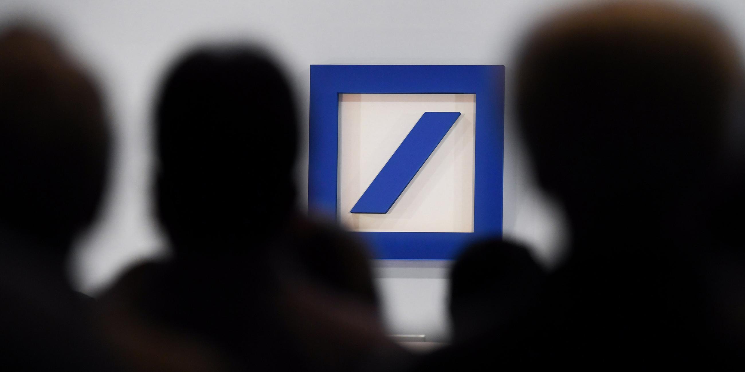 Archiv: Aktionäre sitzen während der Hauptversammlung der Deutschen Bank in der Frankfurter Festhalle vor dem Unternehmenslogo am 24.05.2018