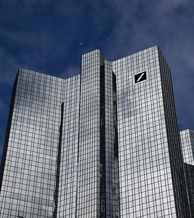 Wolken spiegeln sich auf der gläsernen Fassade der Zentrale der Deutschen Bank.