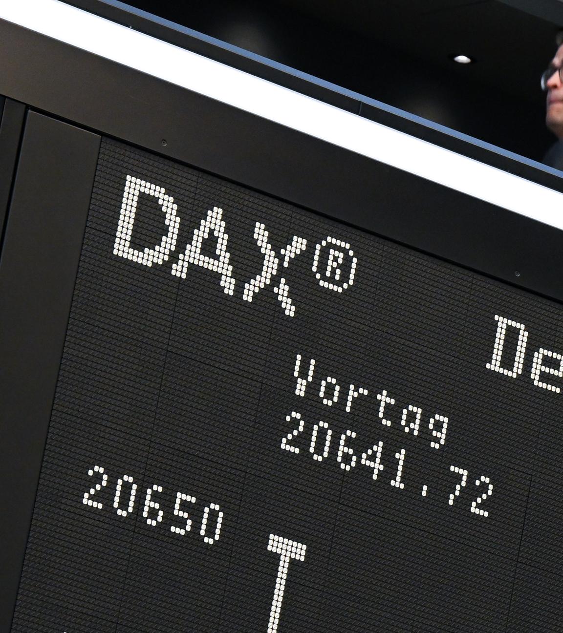 Während ein Besucher auf der Empore der Frankfurter Wertpapierbörse steht, zeigt die Anzeigetafel mit der Dax-Kurve einen starken Verlust an. 