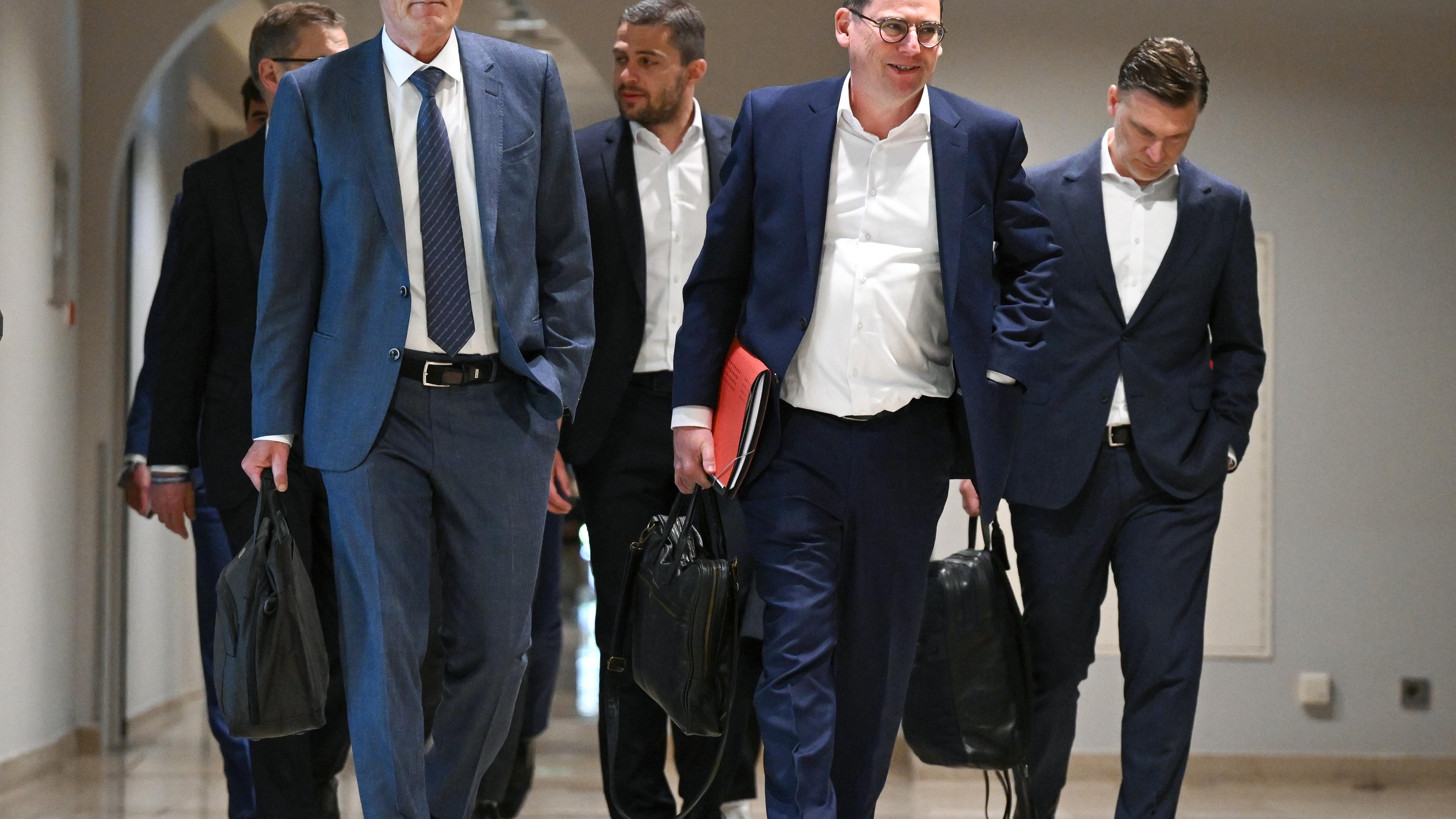 Hessen, Frankfurt/Main: Hans-Joachim Watzke (l) und Oliver Leki (2.v.r.) auf dem Weg in die DFL-Mitgliederversammlung am Frankfurter Flughafen.
