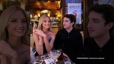 Lara Cosima Pinault und François Pinault Jr. sitzen an einem Tisch in einem Restaurant. Vor ihnen stehen Getränke und Mobiltelefone, im Hintergrund ist der beleuchtete Gastraum zu sehen.