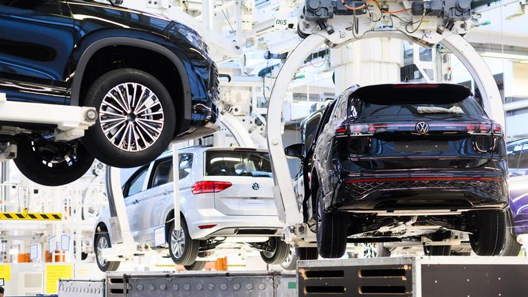 07.03.2025, Niedersachsen, Wolfsburg: Neuwagen Volkswagen Tayron, Tiguan und Touran schweben durch das VW Stammwerk.