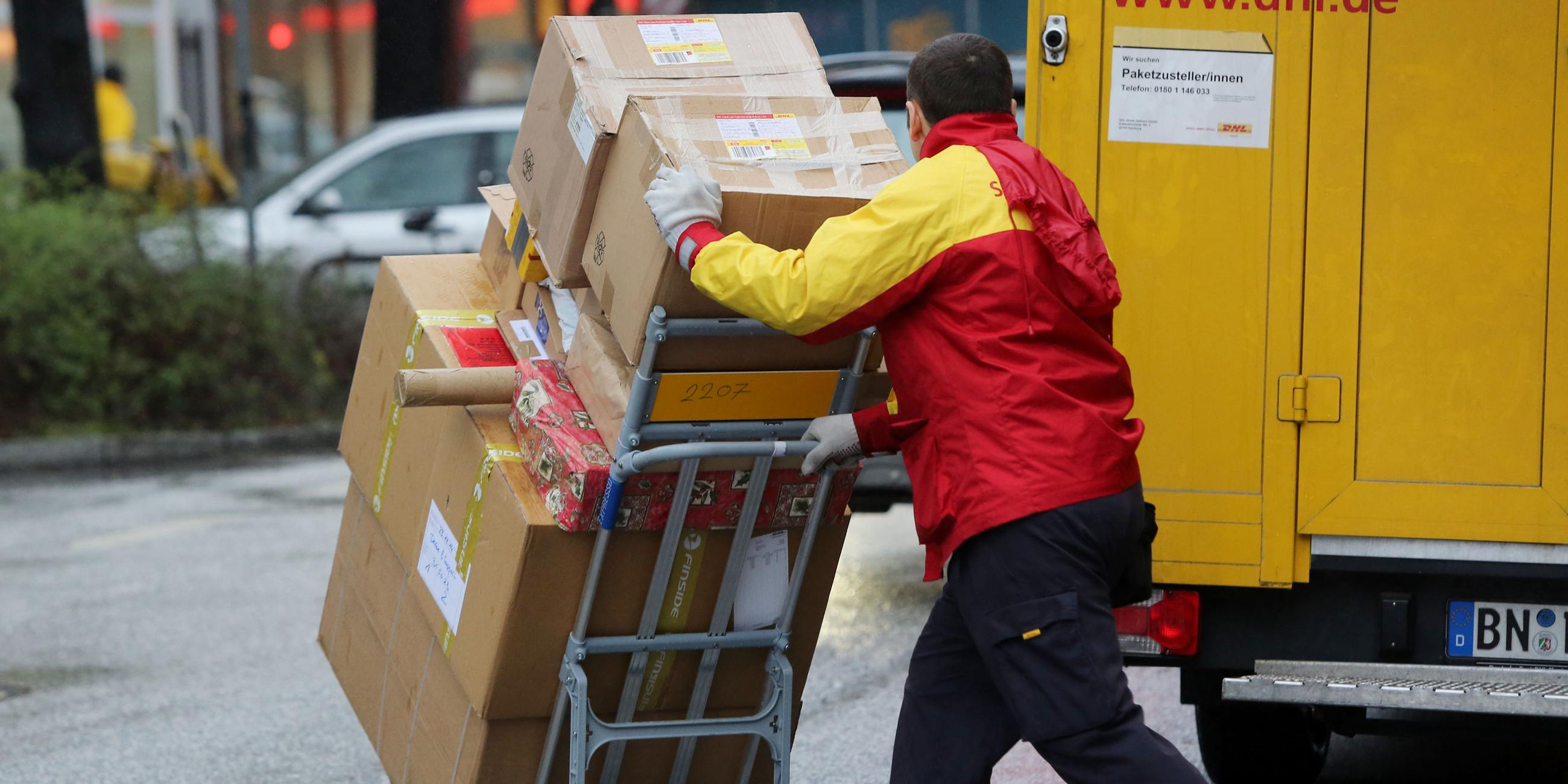 Ein Paketbote der Post liefert ein Päckchen in Hamburg aus.