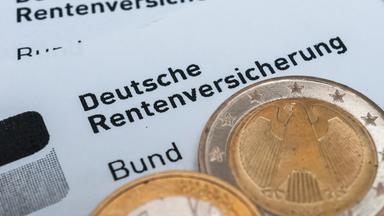 Münzen auf Unterlagen der Deutschen Rentenversicherung.