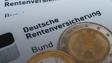 Münzen auf Unterlagen der Deutschen Rentenversicherung.