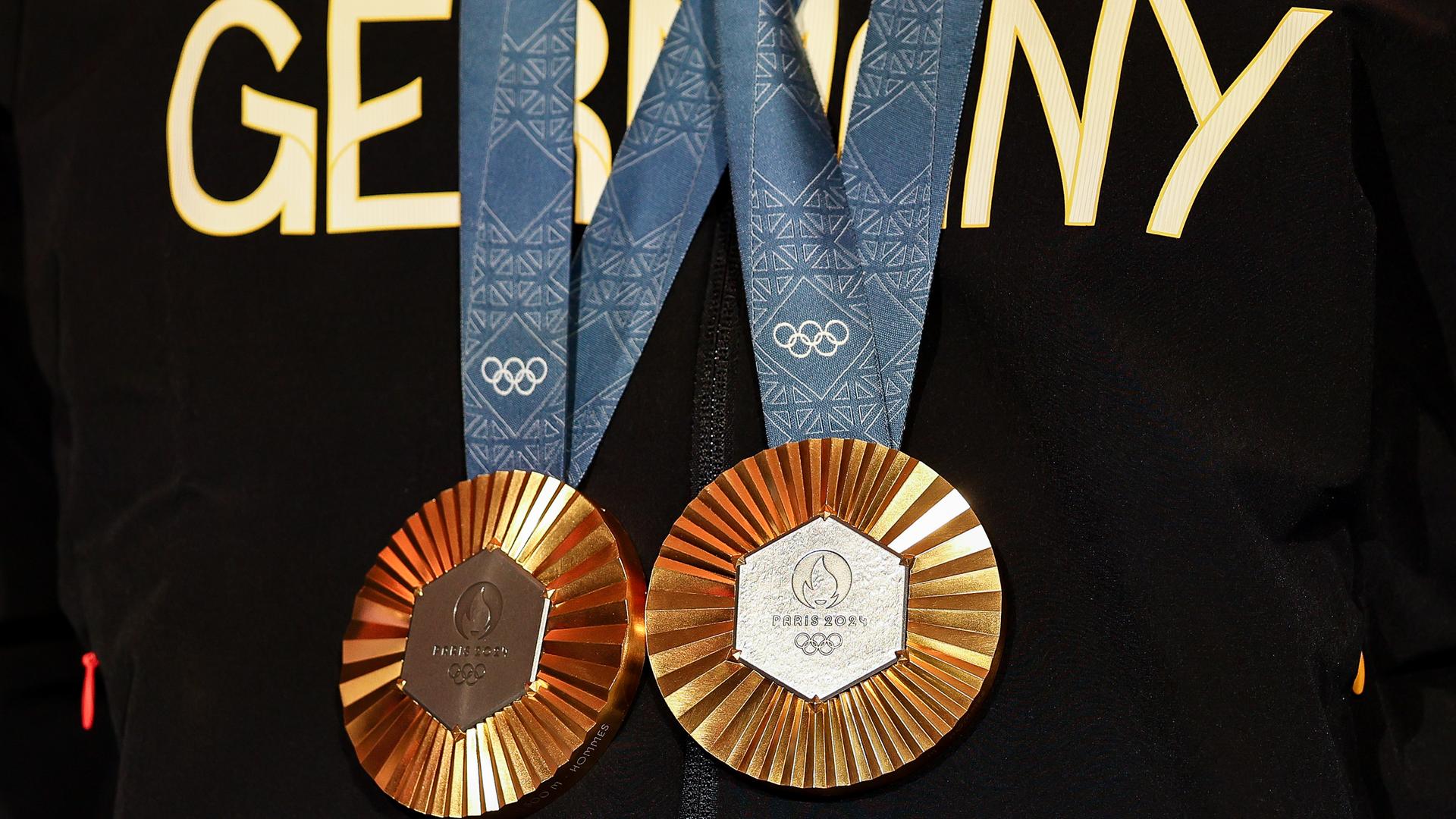 Ein deutscher Athlet hat zwei olympischen Goldmedaillen um den Hals hängen.