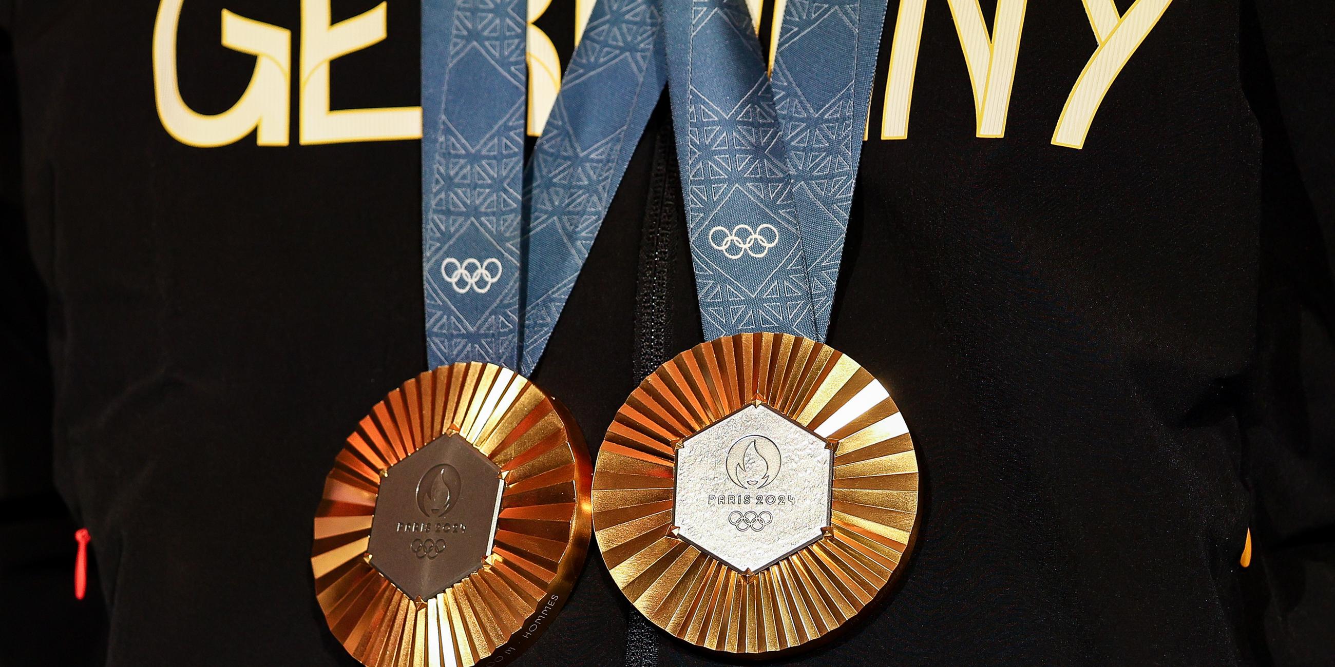 Ein deutscher Athlet hat zwei olympischen Goldmedaillen um den Hals hängen.