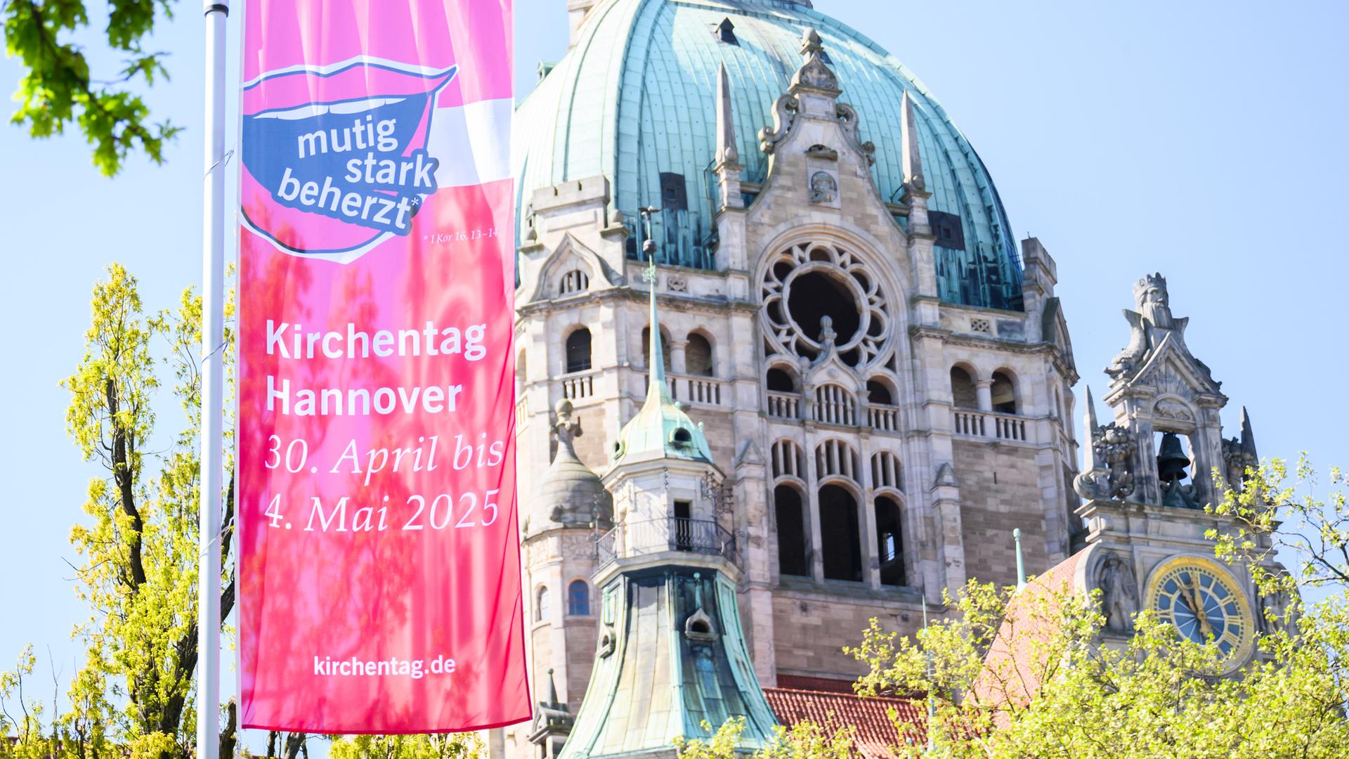 Eine Fahne des Kirchentages hängen am Platz der Menschenrechte vor dem Neuen Rathaus in Hannover.