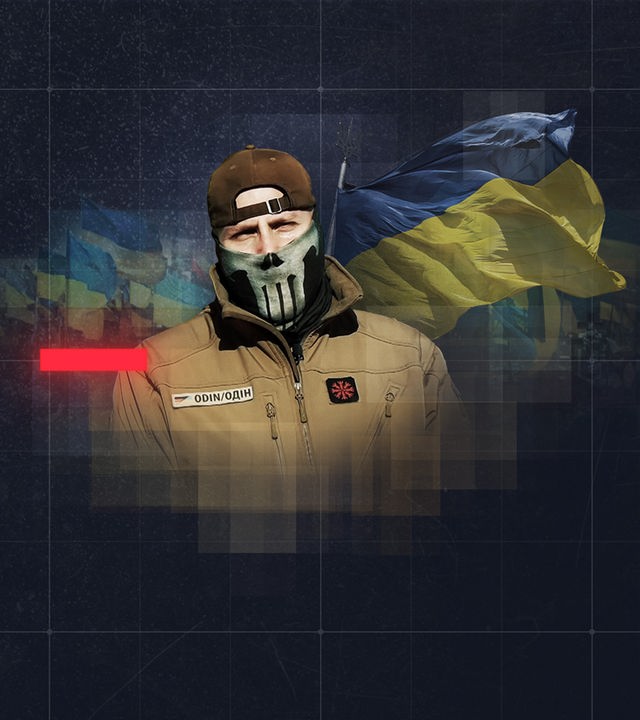 Deutscher Freiwilliger im Ukrainekrieg mit Kampfname Odin vor wehenden ukrainischen Fahnen