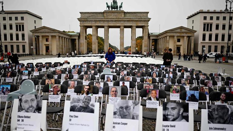 Berlin: Über Tausend Stühle mit Bildern von Opfern des Hamas-Überfalls vom 07.Oktober 2023 stehen vor dem Brandenburger Tor.