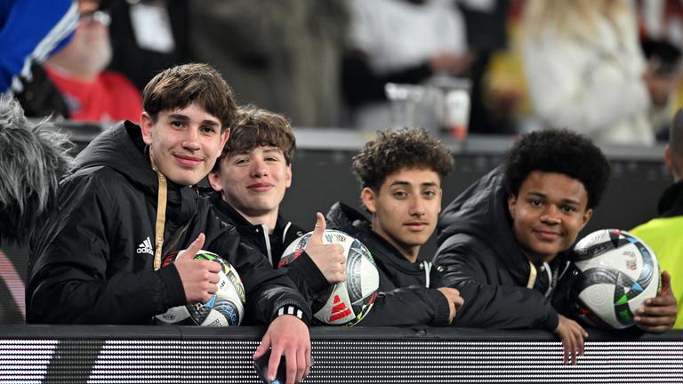 Balljunge Noel Urbaniak (l) und weitere Balljungen sitzen hinter der Bande.