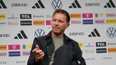 Bundestrainer Julian Nagelsmann sitzt bei einer Pressekonferenz.
